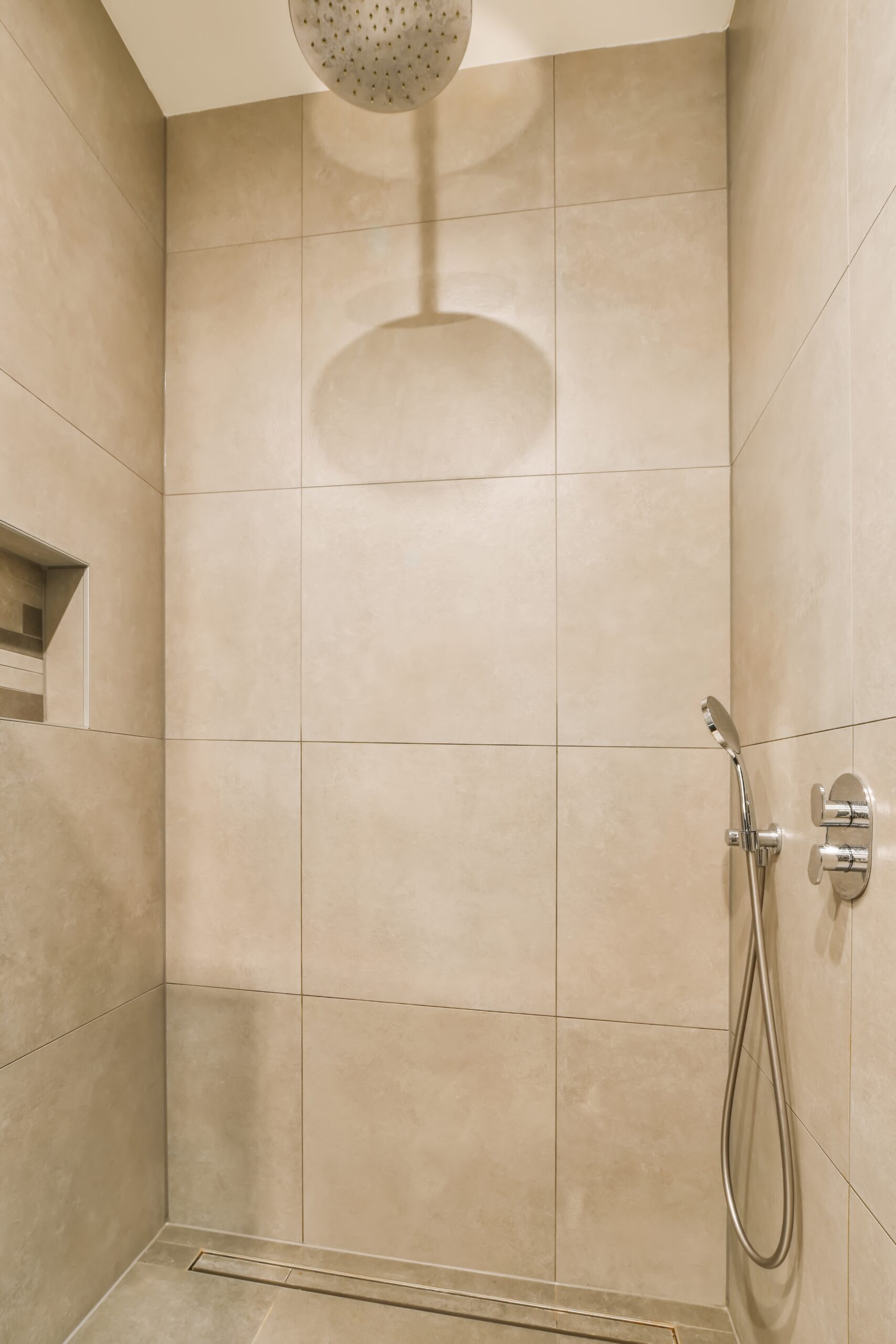 Douche avec carrelage beige aux murs