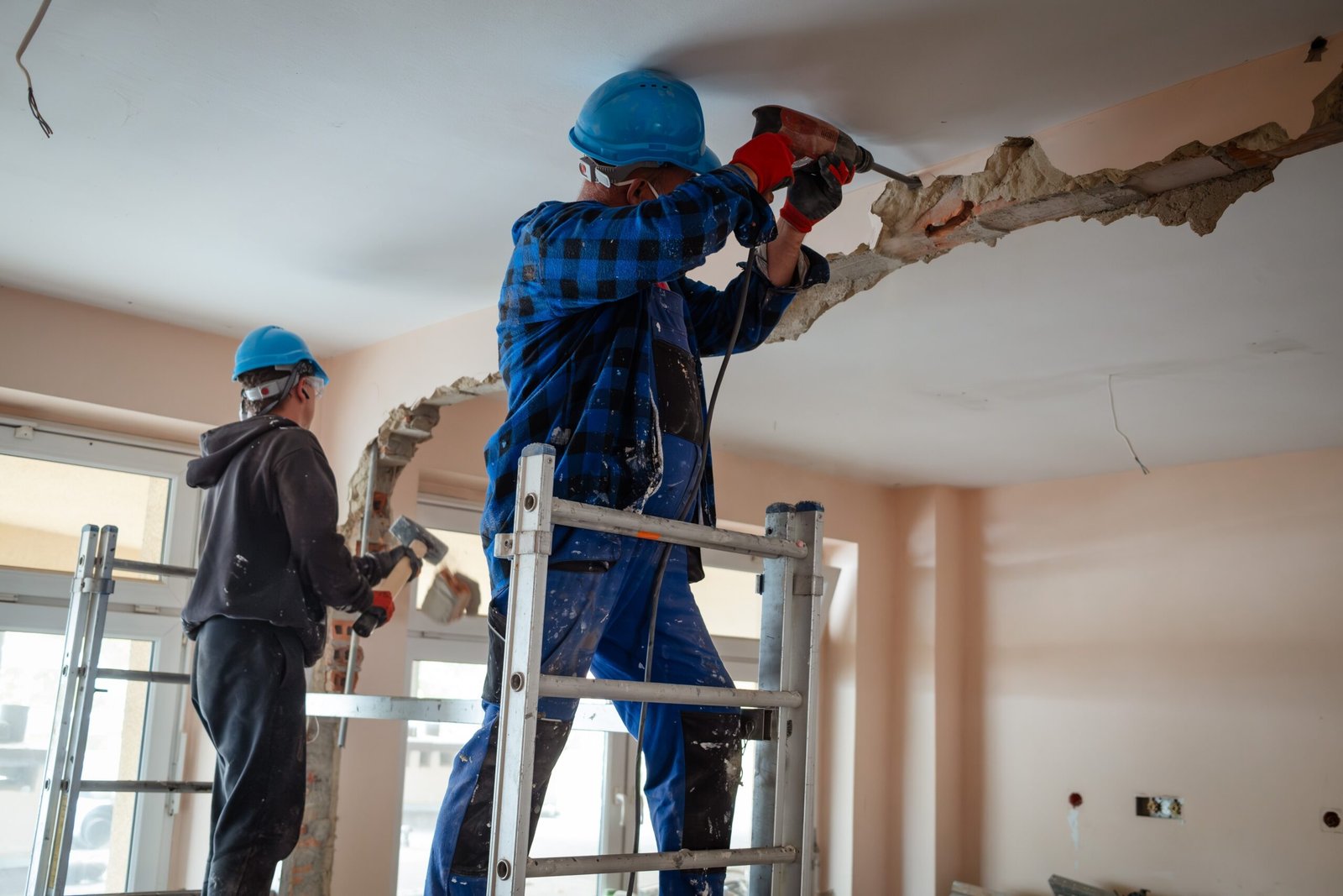 Chantier de démolition en cours, deux ouvriers sur échafaudage
