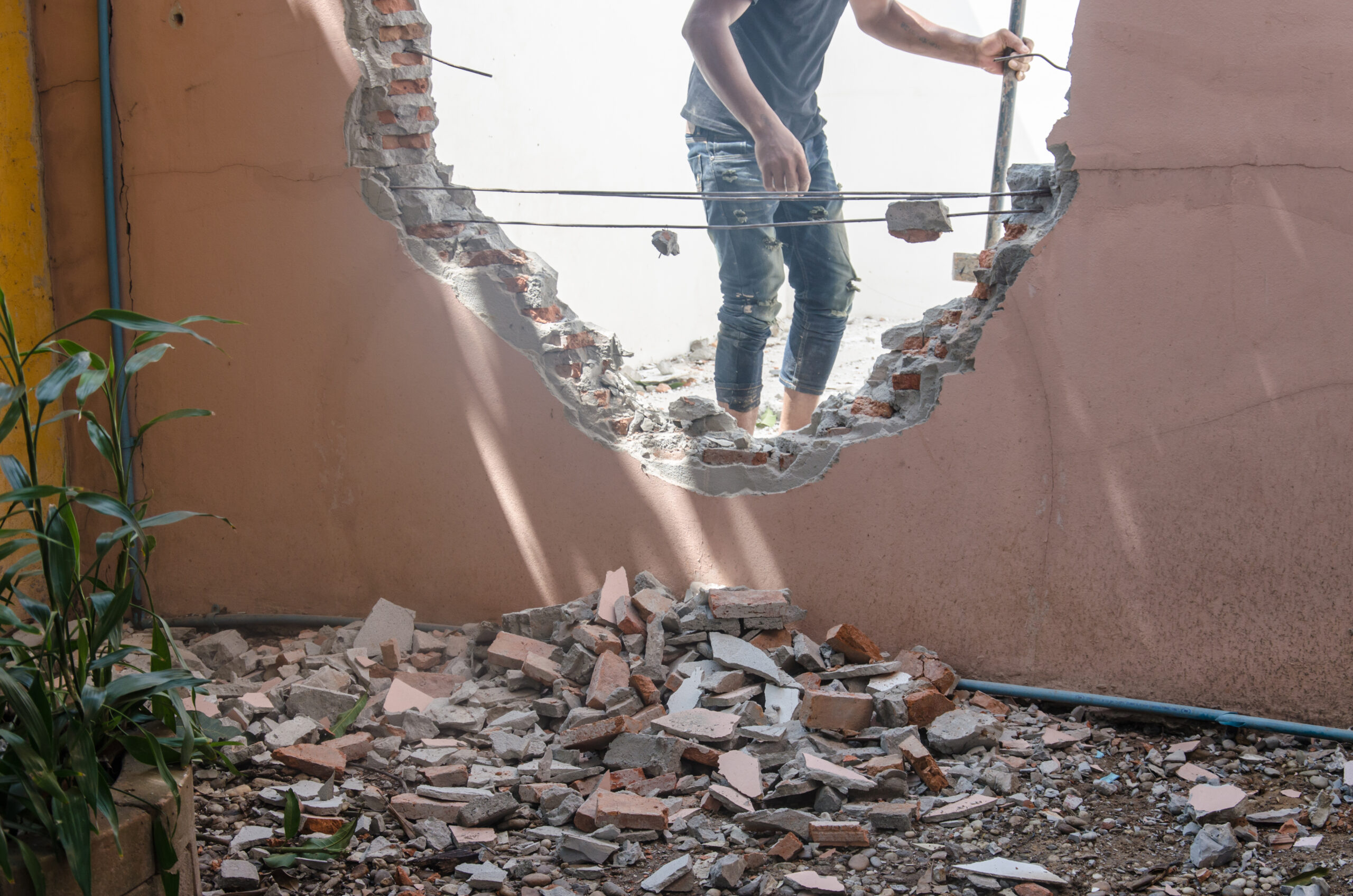 Ouvrier démolissant un mur lors d'un chantier de rénovation